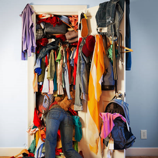 Someone has their legs out and head inside a clustered wardrobe.