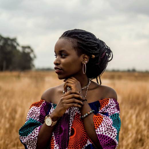 picture of a woman wearing African print off shoulder in a field